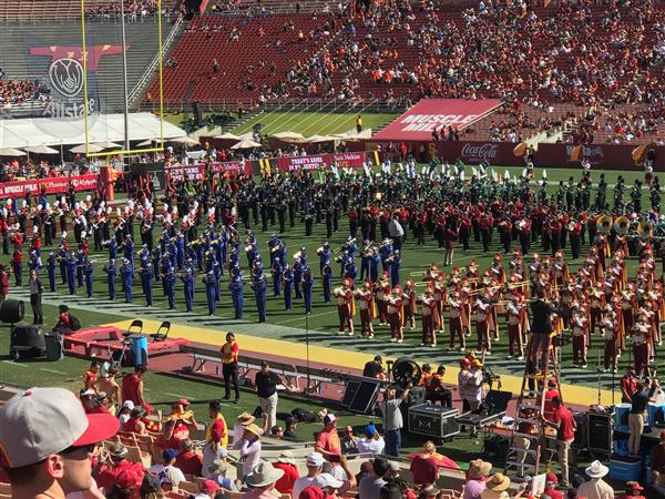 Photo of Magnolia Junior High Band performing next to USC Marching Band in a crowded football stadium